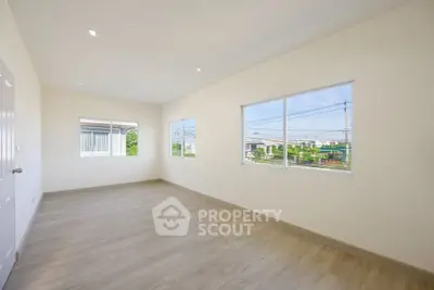 Spacious empty room with large windows and natural light, perfect for customization.