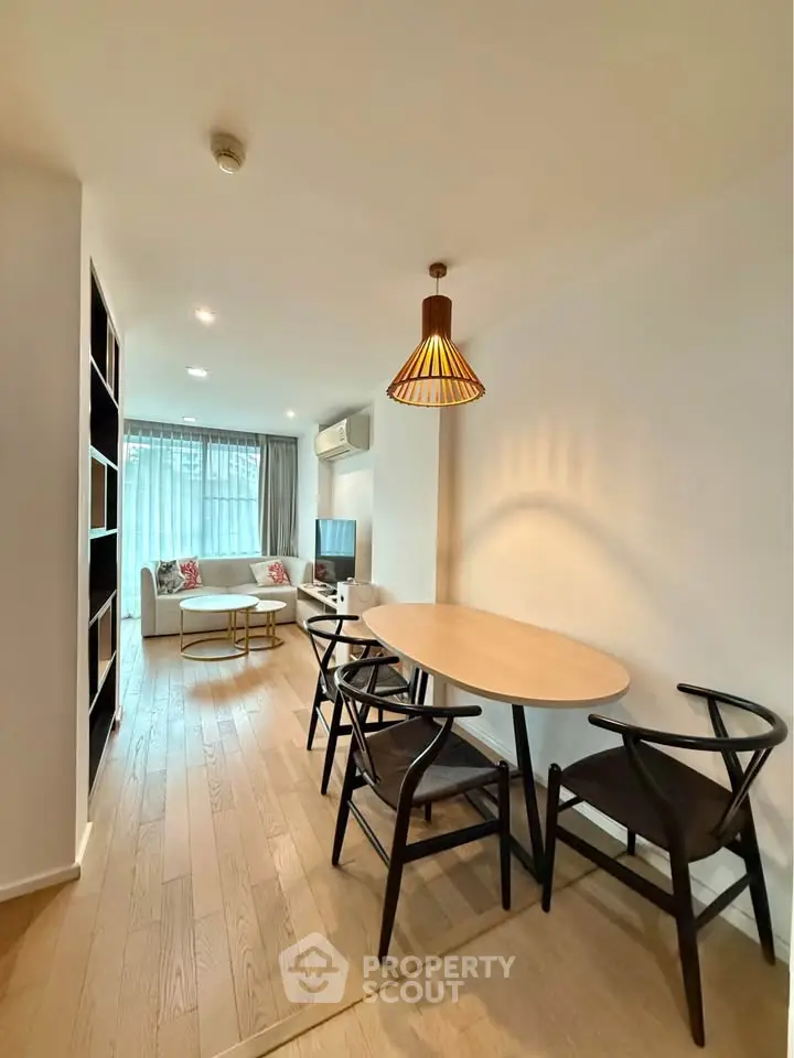Modern living room with dining area, stylish furniture, and natural light