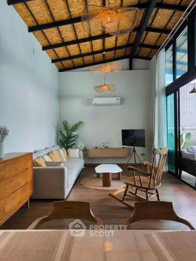 Stylish living room with modern decor and high ceiling, featuring cozy seating and natural light.
