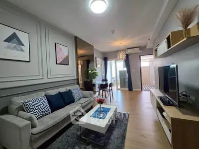 Modern living room with stylish decor and natural light, featuring a cozy sofa and sleek entertainment unit.