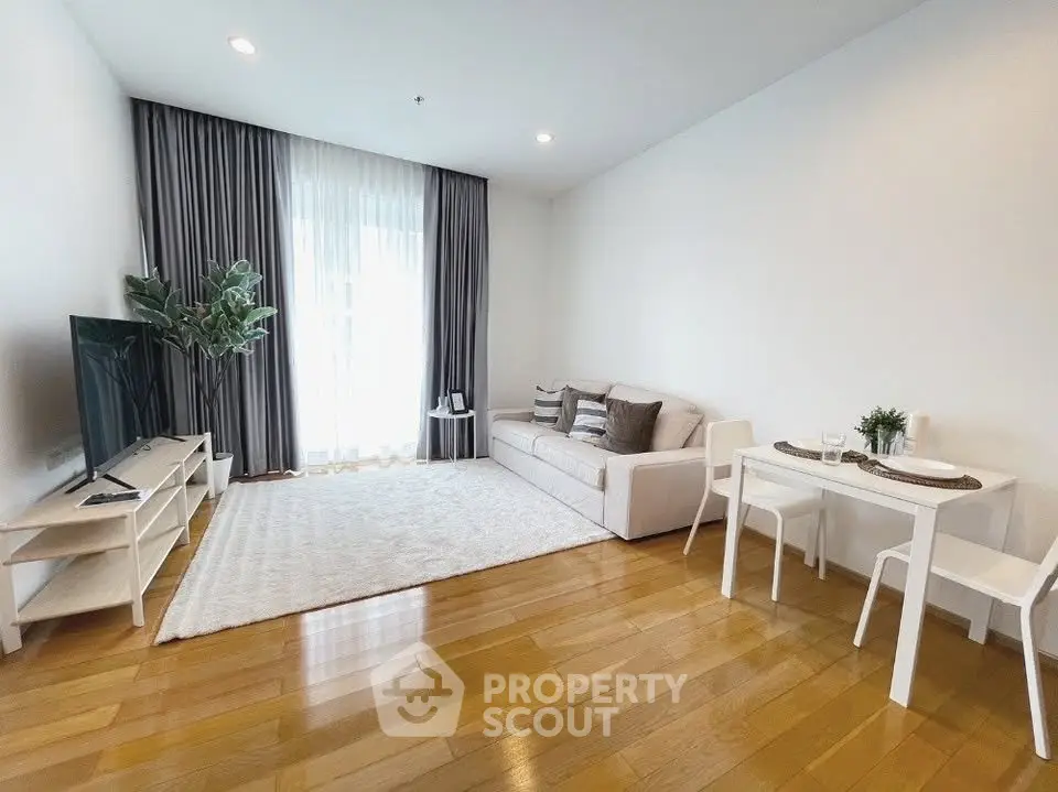 Modern living room with hardwood floors, cozy sofa, and natural light.