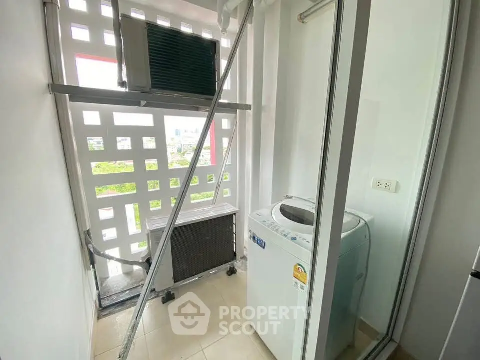 Compact laundry area with washing machine and outdoor view in modern apartment.