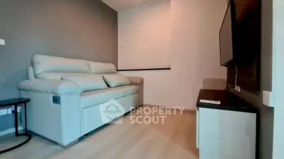 Cozy living room with modern sofa and wall-mounted TV in stylish apartment.