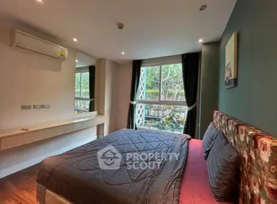 Cozy bedroom with large window and modern decor, perfect for relaxation.