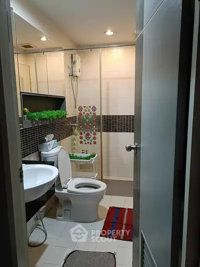 Modern bathroom with stylish decor and efficient layout, featuring a shower and contemporary fixtures.