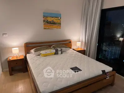 Cozy bedroom with wooden furniture and city view balcony, perfect for relaxation and comfort.