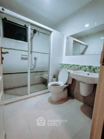 Modern bathroom with glass shower and sleek fixtures in a contemporary home.