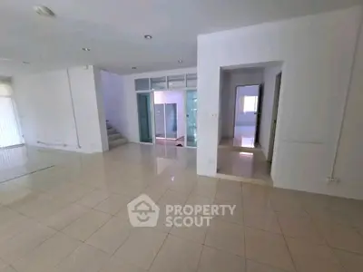 Spacious open-plan living area with modern tiled flooring and ample natural light.