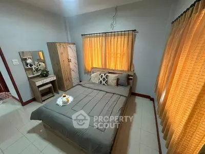 Cozy bedroom with stylish decor and ample natural light from large windows.