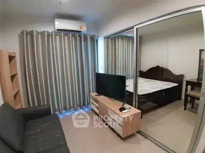 Modern living room with sliding glass doors leading to a cozy bedroom, featuring stylish furniture and neutral decor.