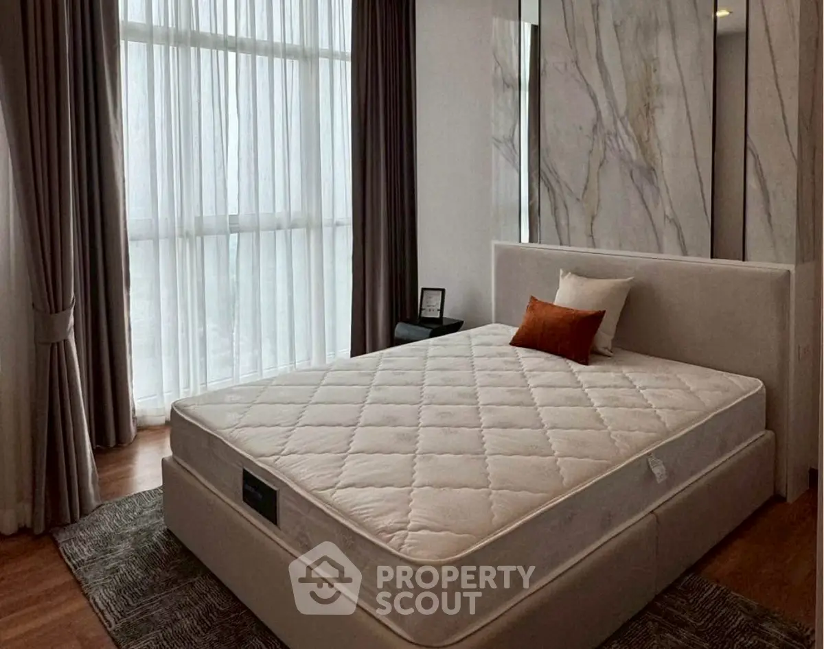 Luxurious bedroom with elegant decor and large windows for natural light.