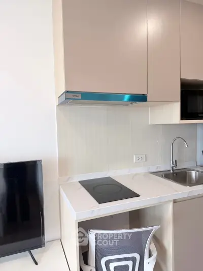 Modern compact kitchen with sleek cabinetry and induction cooktop
