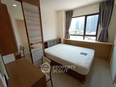 Modern bedroom with large window and city view, featuring sleek furniture and ample natural light.
