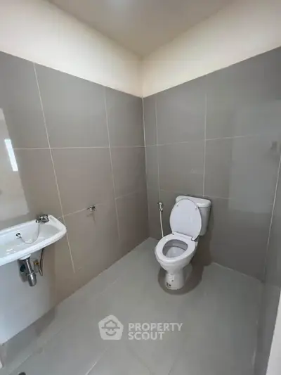 Modern bathroom with sleek gray tiles and white fixtures