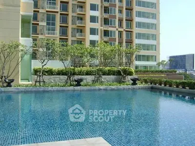 Luxurious residential building with serene pool and lush greenery, perfect for relaxation and leisure.