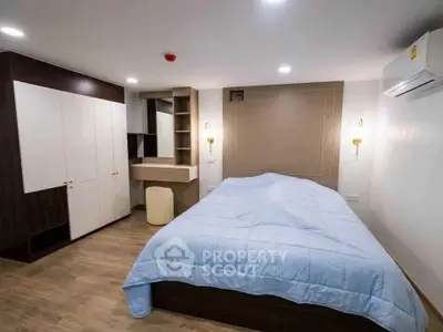 Modern bedroom with stylish furniture and cozy ambiance, featuring a spacious bed and sleek wardrobe.