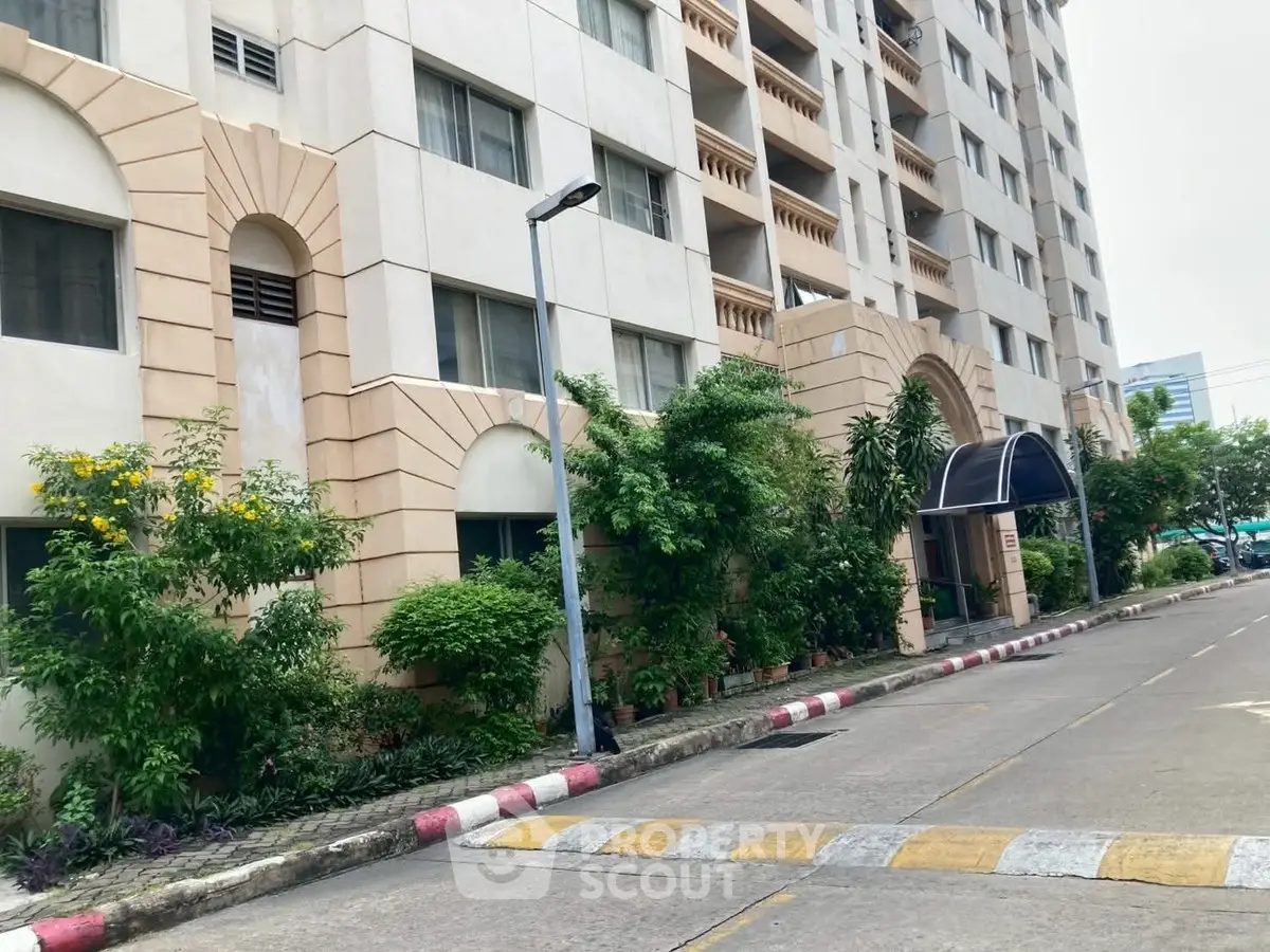 Elegant apartment building exterior with lush greenery and welcoming entrance.