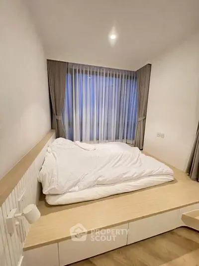 Cozy bedroom with modern design and large window for natural light.