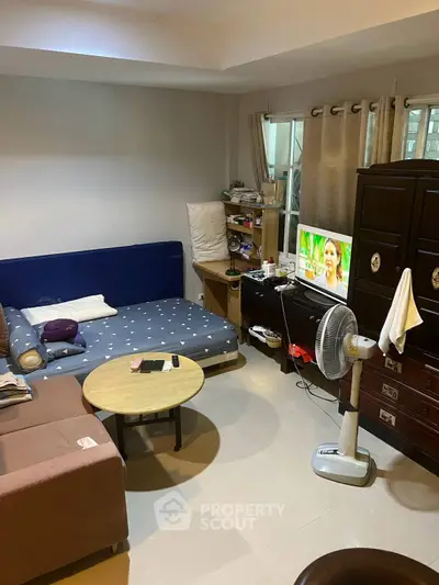 Cozy living room with modern furniture and TV, perfect for relaxation.