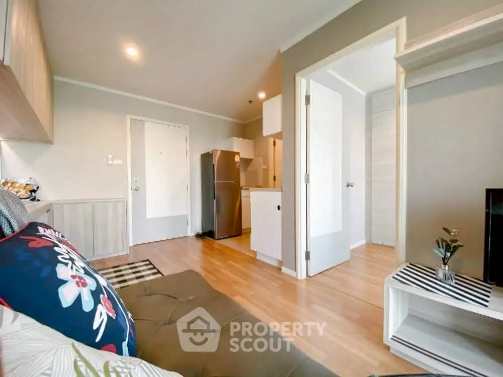 Modern open-layout living room with cozy seating and compact kitchen area.