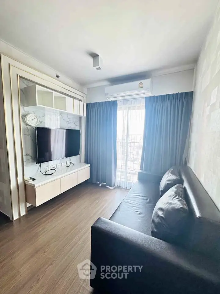 Modern living room with sleek TV setup and stylish sofa, featuring elegant curtains and wooden flooring.