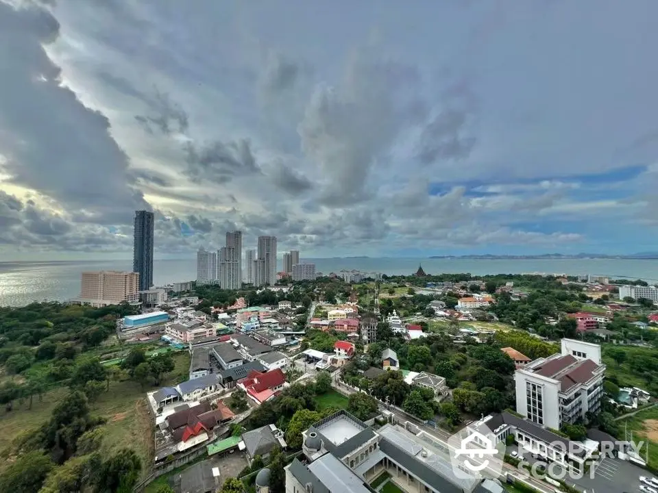 Stunning aerial view of cityscape with ocean backdrop and modern high-rise buildings.