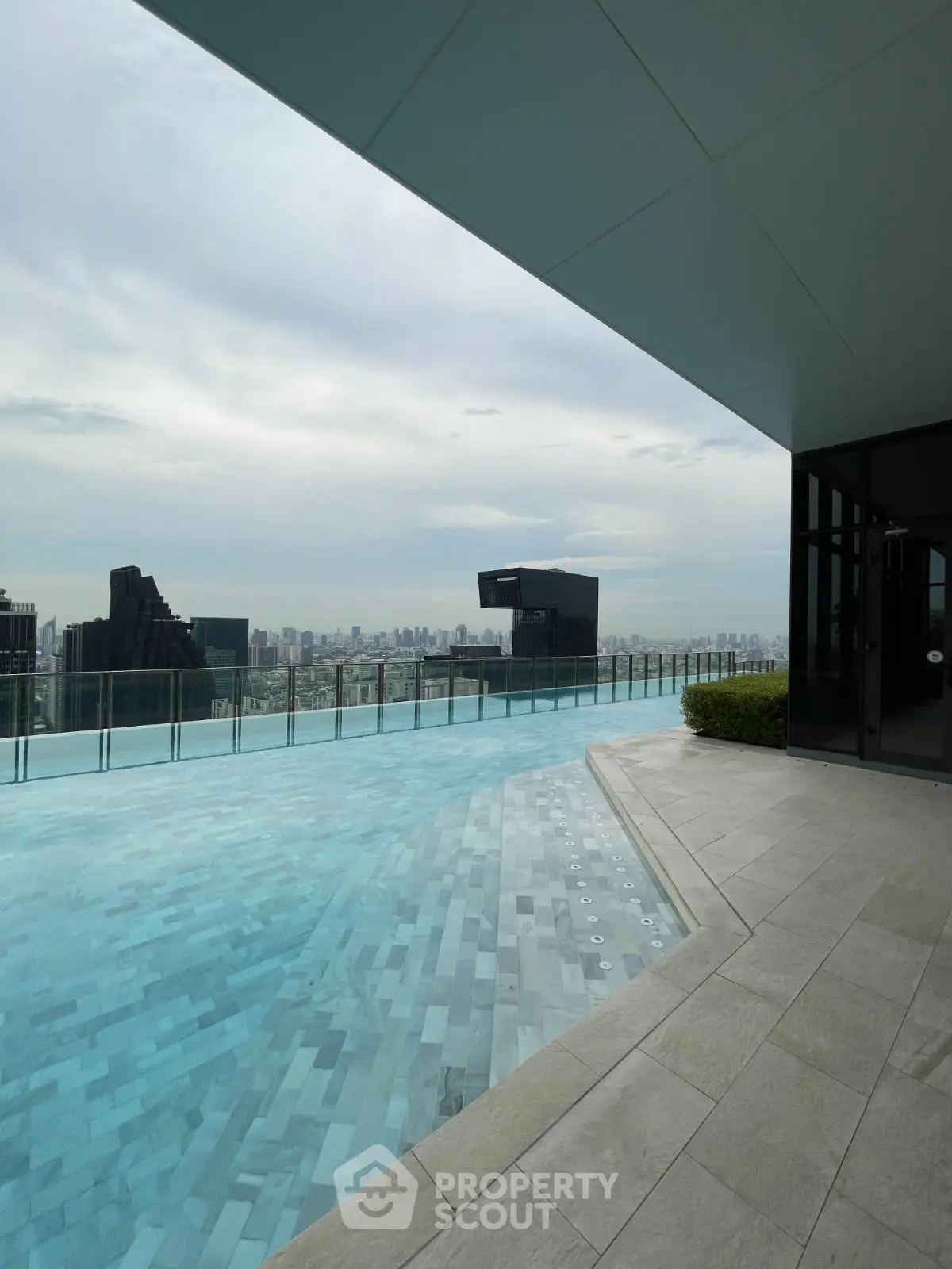 Luxurious rooftop pool with stunning city skyline view, perfect for relaxation and leisure.