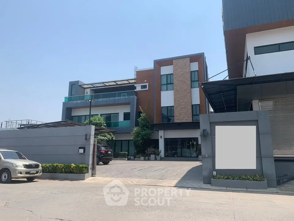 Modern commercial building with sleek design and ample parking space.