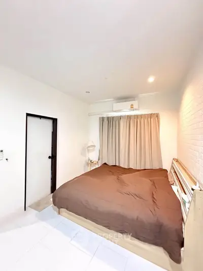 Cozy bedroom with modern decor and air conditioning, perfect for relaxation.