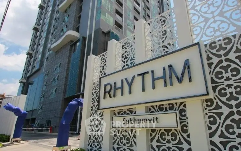 Modern high-rise building exterior with stylish entrance at Rhythm Sukhumvit.