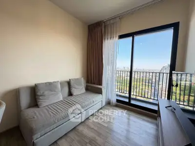Modern living room with cozy sofa and stunning city view from large window balcony.