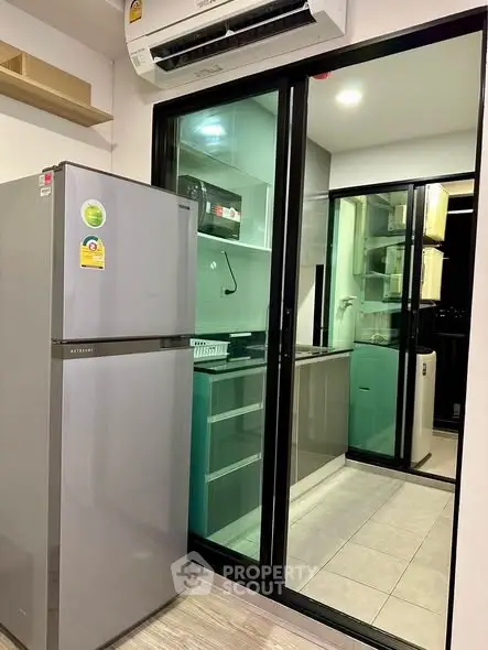 Modern kitchen with sleek appliances and glass sliding door for a stylish urban living experience.