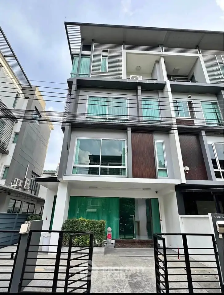 Modern multi-story building with sleek design and large windows in urban setting.