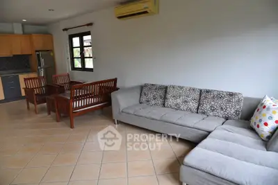 Spacious living room with modern furniture and open kitchen layout, perfect for family gatherings.