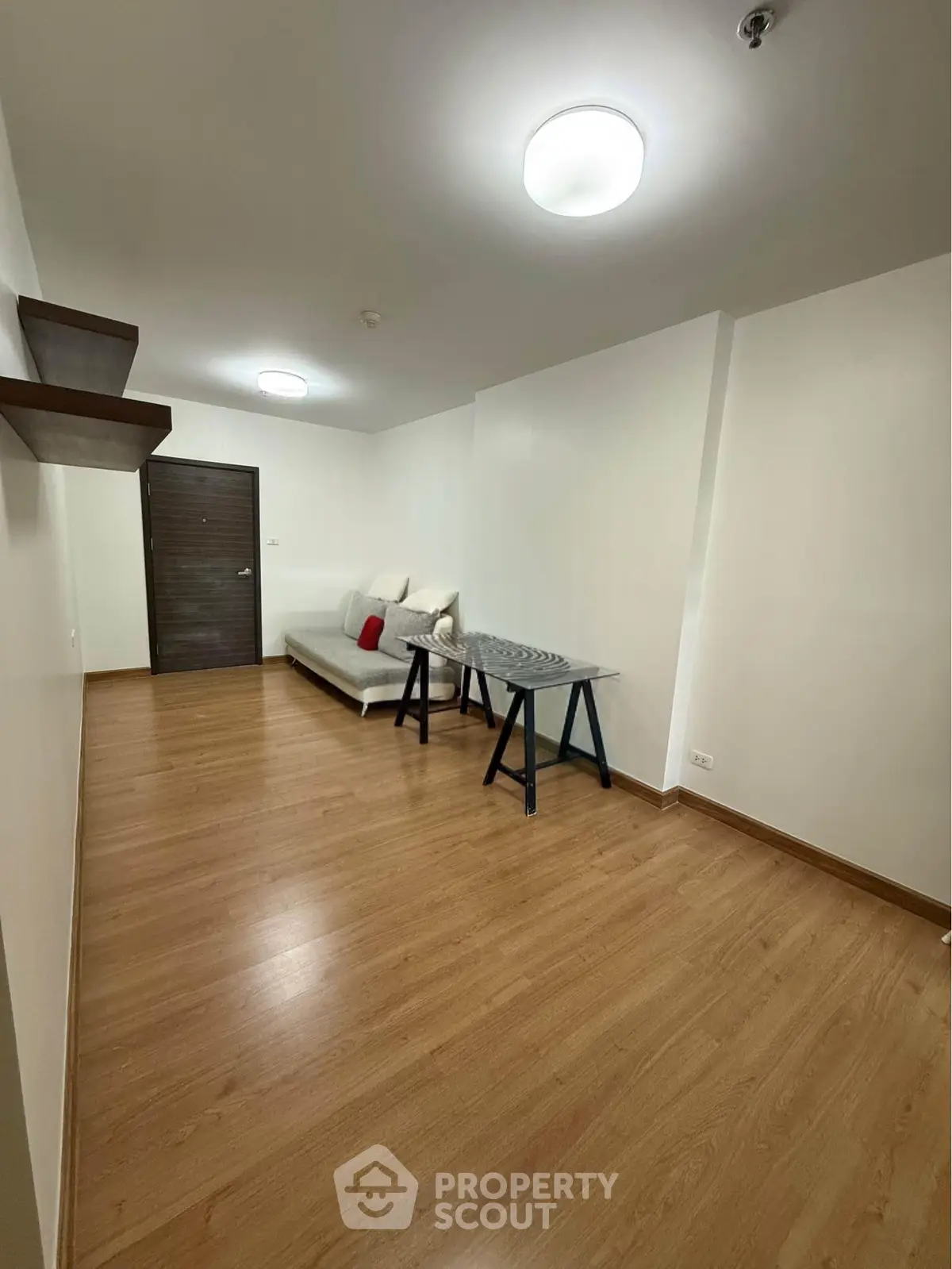 Spacious living room with modern decor and wooden flooring, perfect for relaxation and entertaining.