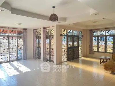 Spacious living room with large windows and decorative metalwork, perfect for natural light lovers.