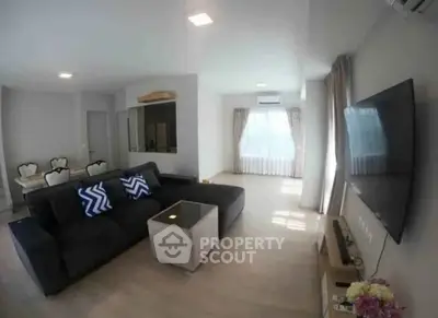 Spacious modern living room with stylish decor and large TV