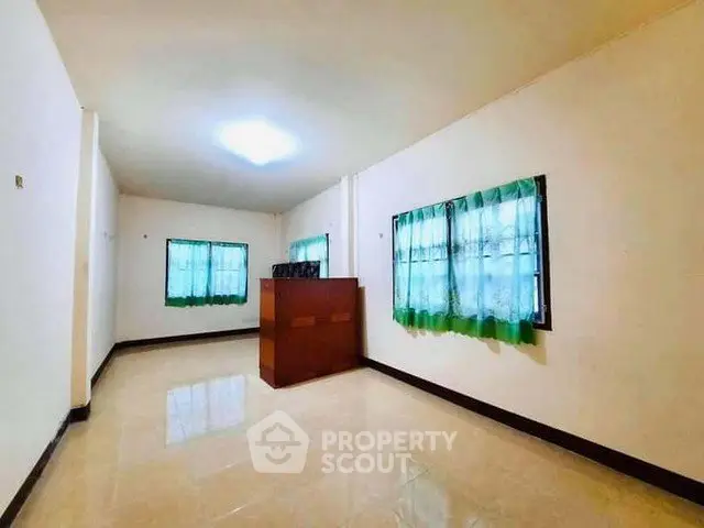 Spacious empty room with tiled flooring and green curtains, ideal for customization.