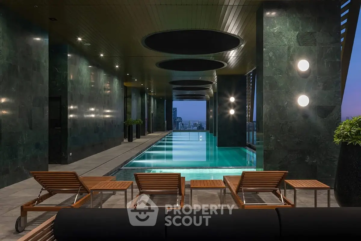 Luxurious indoor pool with sleek design and city view, perfect for relaxation and leisure.