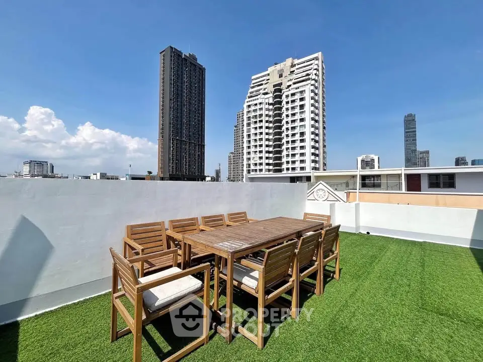 Stunning rooftop terrace with city skyline views and outdoor dining area.