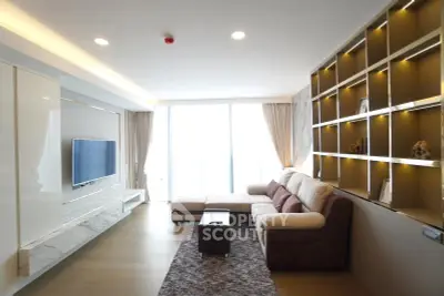 Modern living room with sleek design, large TV, and cozy sectional sofa, perfect for relaxation and entertainment.