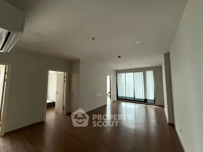 Spacious modern living room with hardwood floors and large windows
