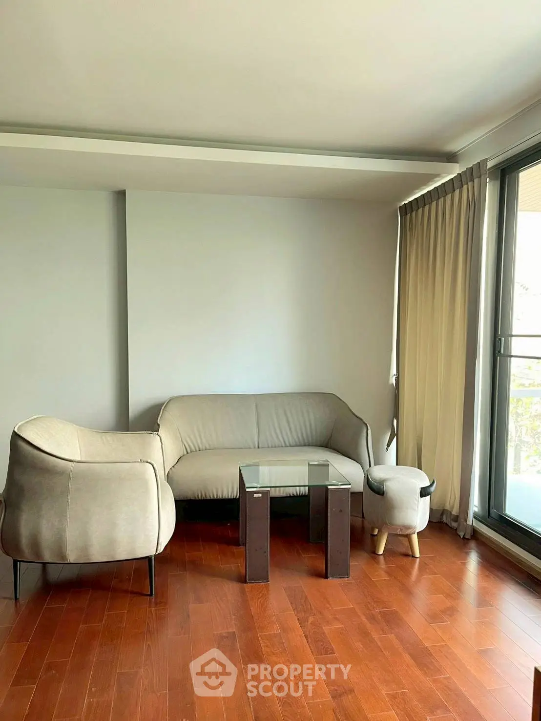Modern living room with sleek furniture and large window for natural light.