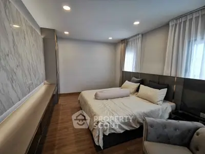 Luxurious modern bedroom with elegant decor and ample natural light.