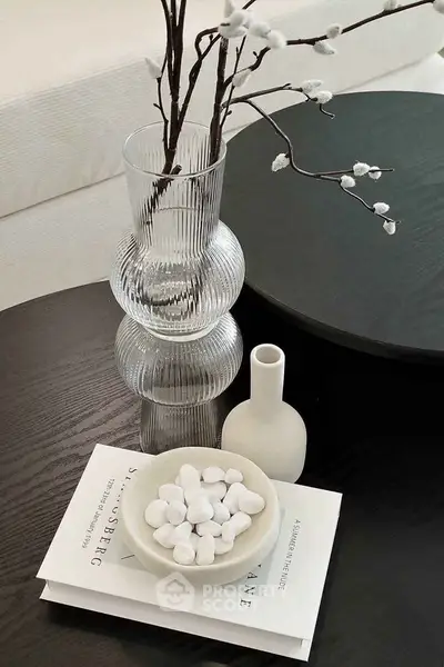 Elegant living room decor with modern vase and books on a stylish coffee table.