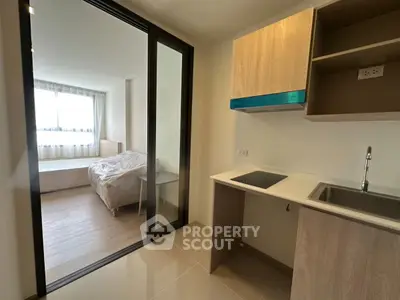 Modern studio apartment with compact kitchen and cozy bedroom