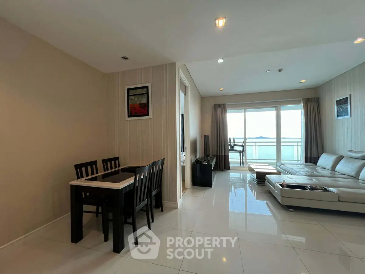 Spacious living room with modern decor and stunning ocean view from large windows.