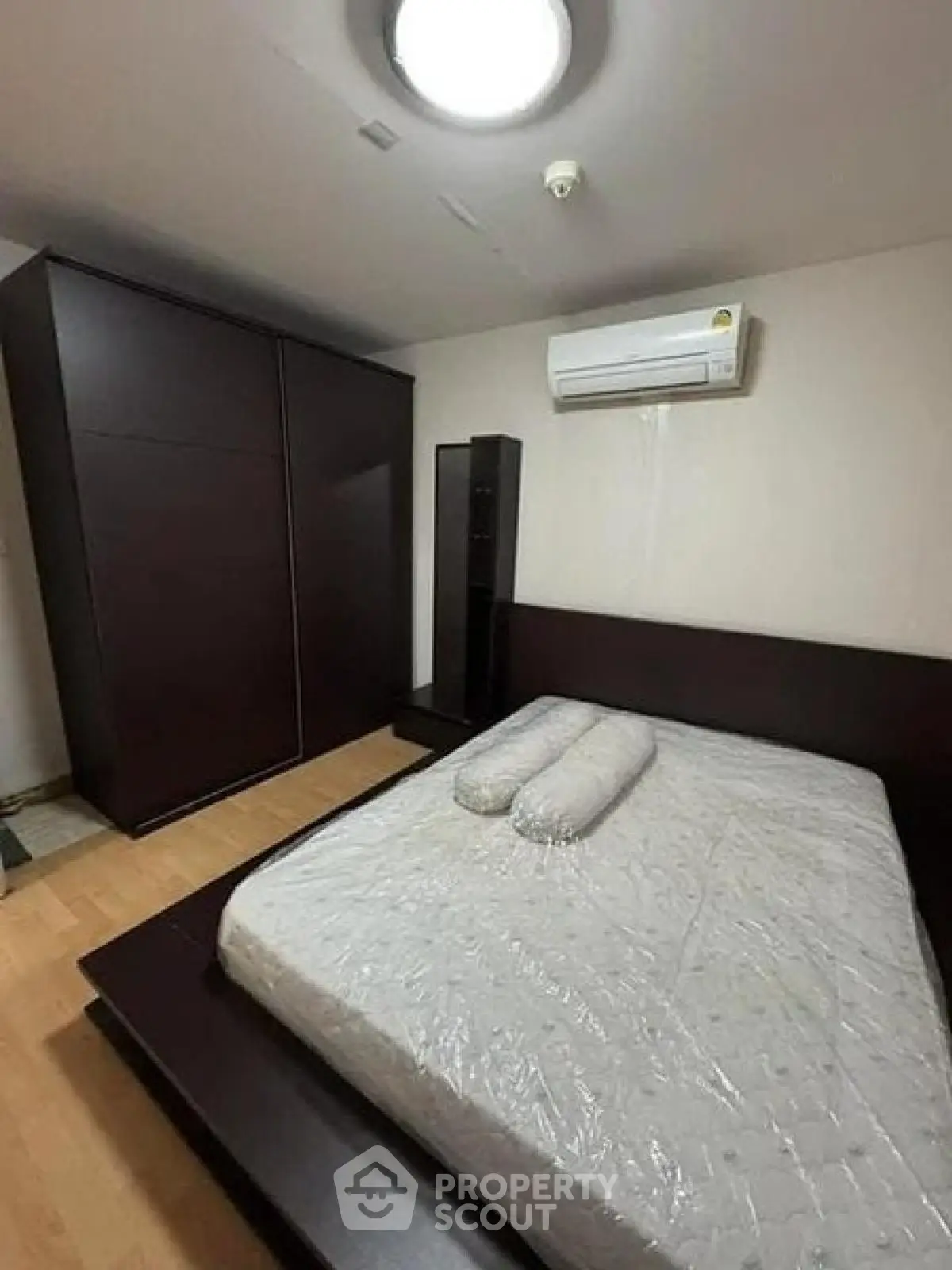 Spacious bedroom with modern furniture and air conditioning, perfect for comfort and relaxation.