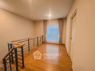 Spacious interior with wooden flooring and elegant railing, perfect for a cozy living area.
