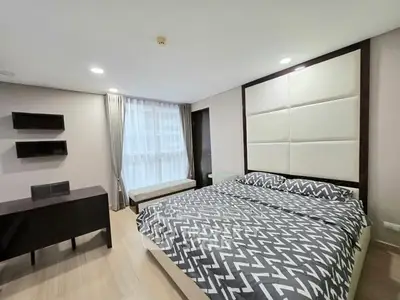 Modern bedroom with stylish decor and large window in a contemporary apartment.